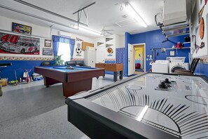 Relax and unwind in this sports-themed room, featuring a pool table, air hockey, and cozy seating area.