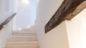 A staircase with white steps and a metal handrail, leading to a bright area beyond. - Blanda Family Apartment (Blanes)