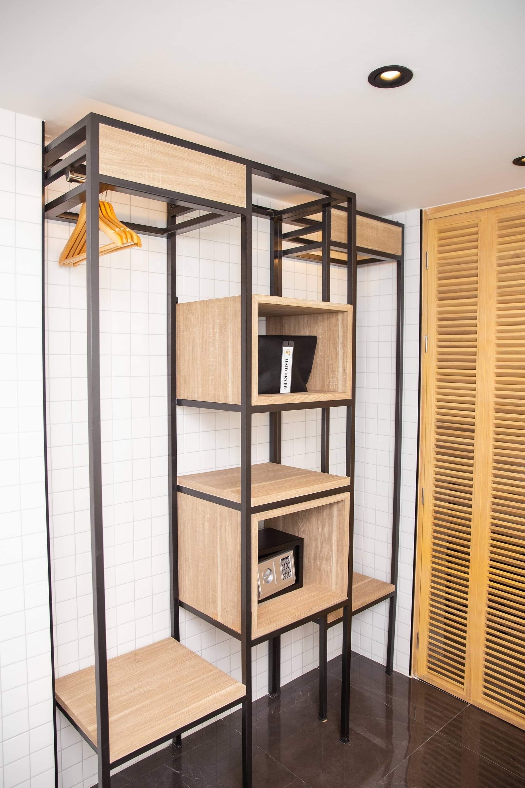 A corner storage unit with multiple shelves and a small cabinet, featuring a wooden finish and black metal frame.