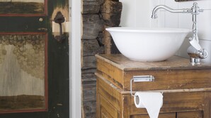 Une salle de bain avec un meuble-lavabo en bois, un lavabo blanc et un miroir.