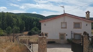 A building with a stone facade, a red roof, and a fenced courtyard. - RURAL HOUSE IDEAL FOR CELEBRATIONS, LARGE LIVING ROOM, BARBECUE, 18 PEOPLE (Valdemoro-Sierra)