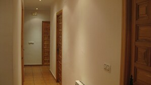 A narrow hallway with wooden doors and white walls. - RURAL HOUSE IDEAL FOR CELEBRATIONS, LARGE LIVING ROOM, BARBECUE, 18 PEOPLE (Valdemoro-Sierra)