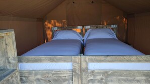 A small, cozy room with a wooden bunk bed and a single bed.