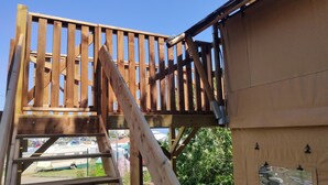 A wooden structure with a staircase and a metal railing.