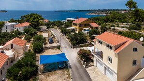 A coastal residential area with houses, a road, and a view of the sea. - Apartments Fran (Vela Luka)