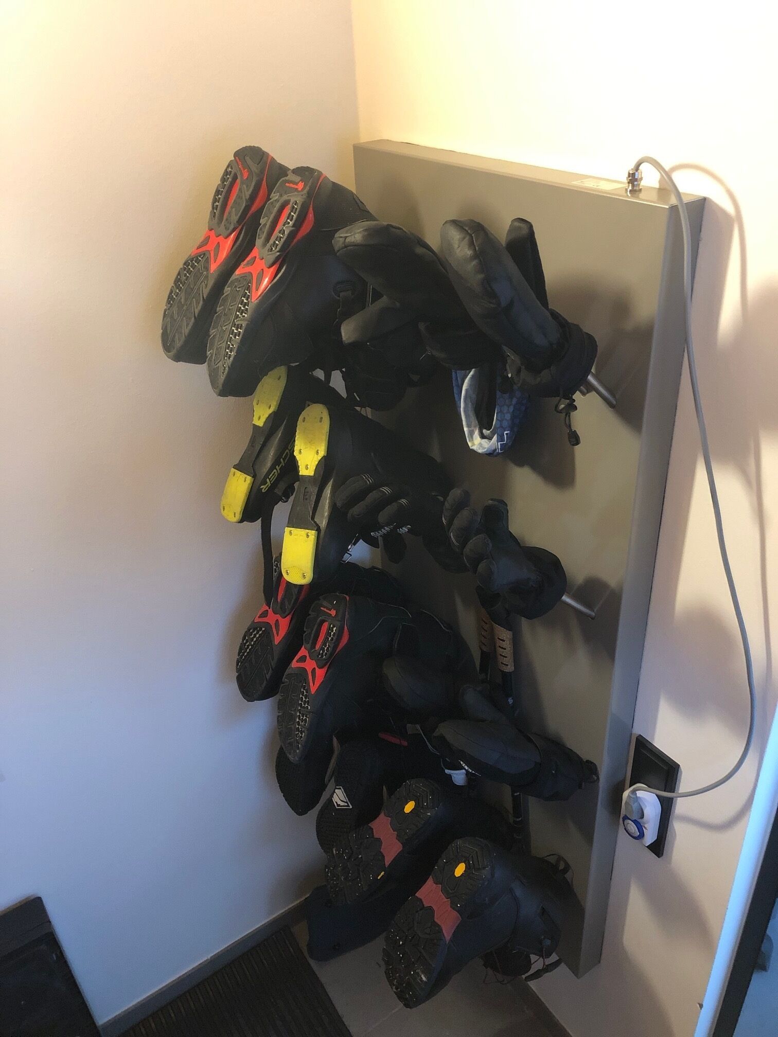 Ein wandmontierter Schuhregal mit mehreren Paar Motorradstiefeln.