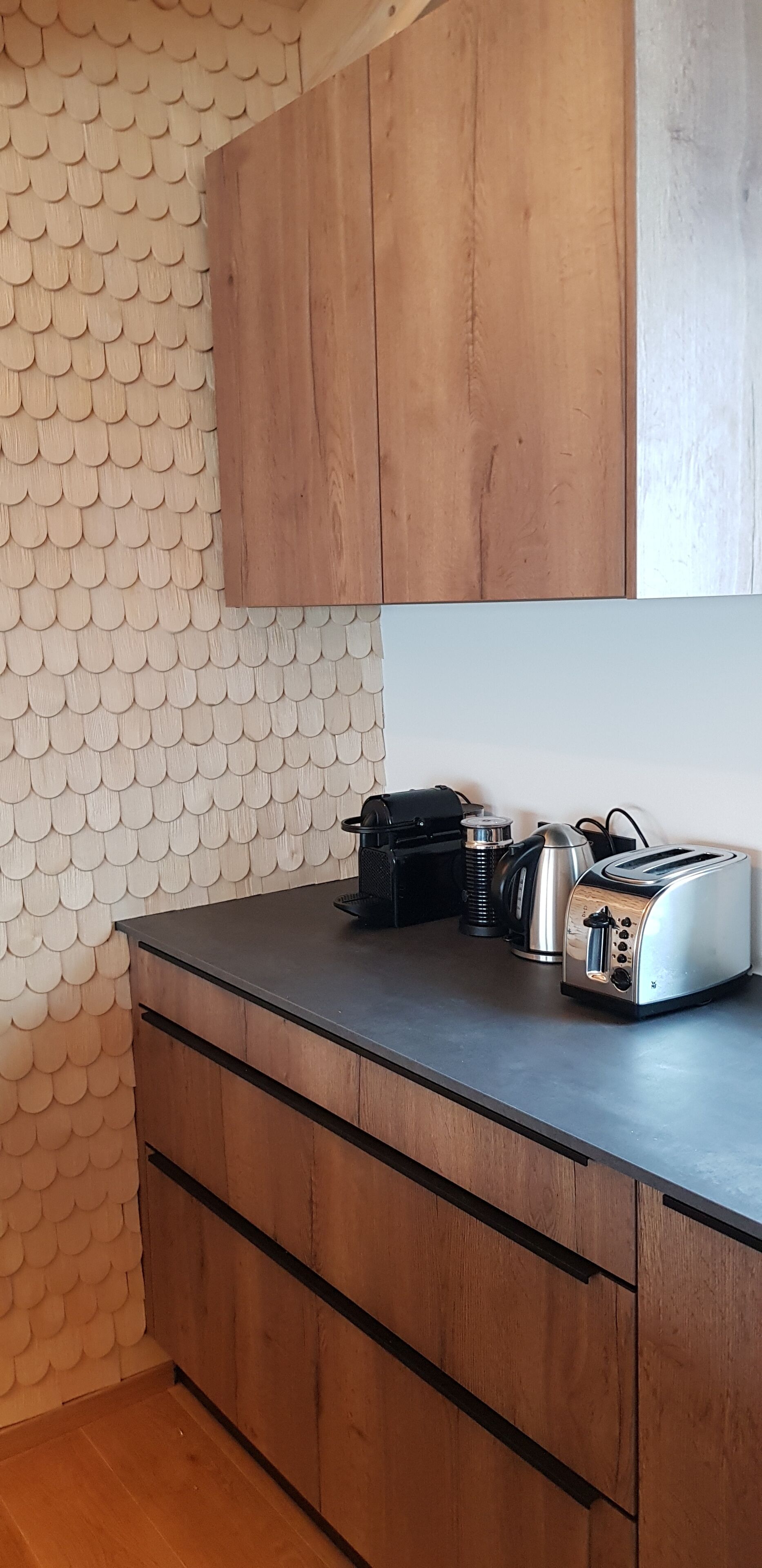 Cucina con mobili in legno, un piano di lavoro e un tostapane.
