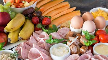 A variety of food items including fruits, vegetables, meats, and eggs arranged on a table.