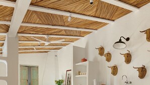 A dining area with a round table, wicker chairs, and a ceiling with thatched beams. - Spectacular unique villa in the Emporda (Calabuig)