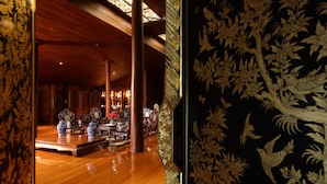 Un intérieur traditionnel avec des planchers en bois, des meubles richement décorés et des panneaux ornementaux.