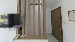 Ein Empfangsbereich mit einem Flachbildfernseher, einem Telefon und einer Holzwand.