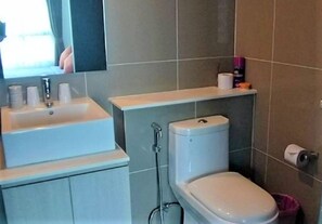 A bathroom with a sink, toilet, and shower.
