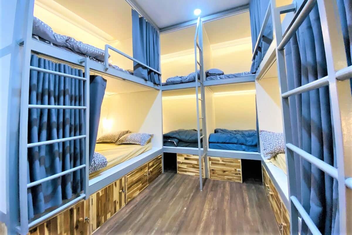 Ein kompakter, mehrstöckiger Schlafraum mit Holzboden und Metallgeländern.