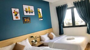 Habitación de hotel con dos camas, un ventanal con cortinas y una obra de arte en la pared con personajes de dibujos animados.