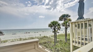 A beach view from a balcony with a railing, palm trees, and a statue. - 146 The Shores (Panama City Beach)