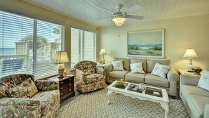 A living room with a ceiling fan, two sofas, a coffee table, and a painting on the wall. - 146 The Shores (Panama City Beach)
