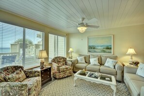 A living room with a ceiling fan, two sofas, a coffee table, and a painting on the wall.