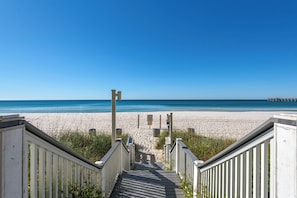 A wooden staircase leading to a beach with a clear blue sky. - Calypso Resort by BBG (Panama City Beach)