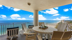 Een balkon met uitzicht op de oceaan en een stadsbeeld.