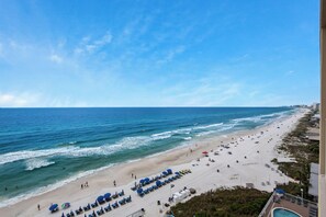A beach with rows of sun loungers and umbrellas, a pool, and a view of the ocean. - Seychelles Beach Resort 901 - 99987 (Panama City Beach)