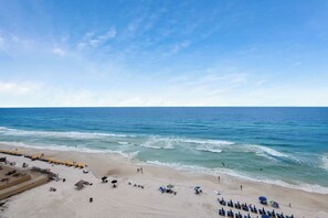 A beach with rows of sun loungers and umbrellas, a sandy shore, and the ocean. - Seychelles Beach Resort 901 - 99987 (Panama City Beach)
