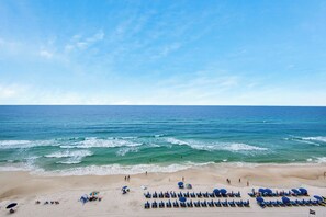 A beach with rows of sun loungers and umbrellas, a sandy shore, and the ocean. - Seychelles Beach Resort 901 - 99987 (Panama City Beach)