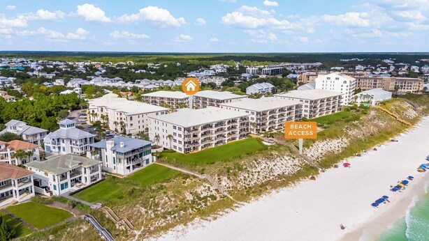 A beachfront hotel with multiple balconies, a beach access sign, and a view of the ocean. - Sol Mate Unit C304 (Santa Rosa Beach)