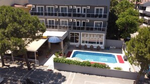 A multi-story building with a swimming pool, outdoor seating, and potted plants. - Famous Hotel Marmaris (Marmaris)