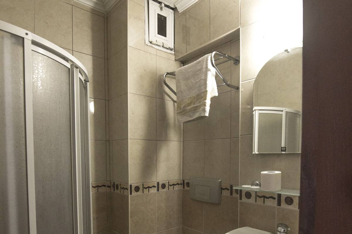 A bathroom with a shower, toilet, and sink.