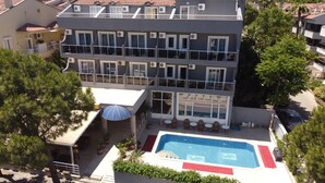 A multi-story building with a rooftop pool, outdoor seating, and potted plants. - Famous Hotel Marmaris (Marmaris)
