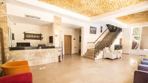A reception area with a reception desk, a staircase, and seating areas. - Famous Hotel Marmaris (Marmaris)