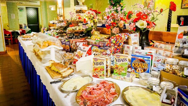 A buffet table with various food items, including bread, cheese, and deli meats. - Hotel Cristallo (Riolo Terme)
