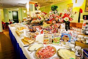 Una mesa de buffet con diversos alimentos, como pan, queso y embutidos.