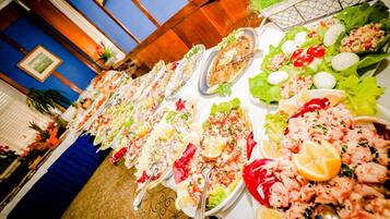A long table with various seafood dishes, including shrimp and salads, in a restaurant setting.