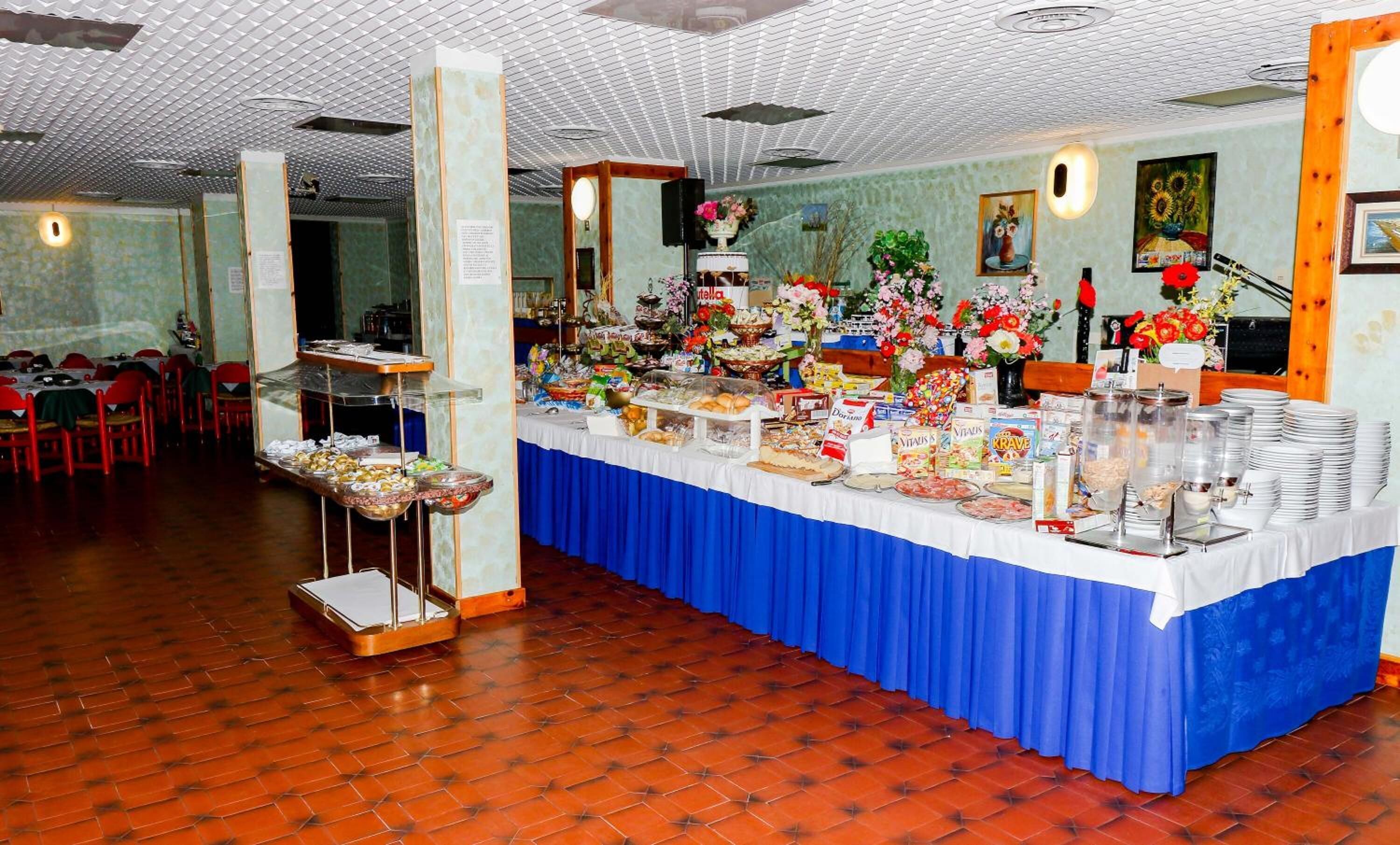 Montaje de bufé con diversos alimentos y un mantel azul.