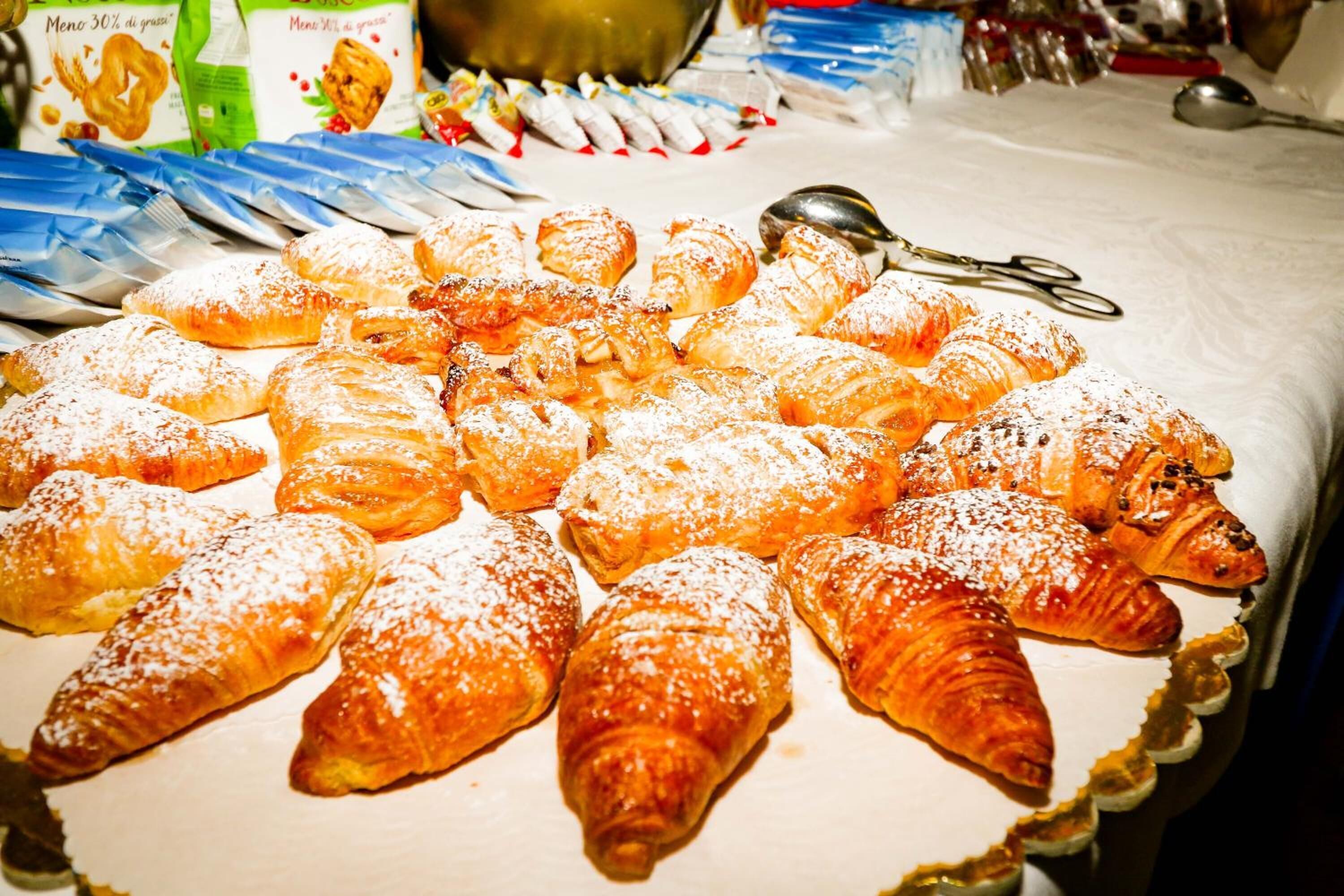 A variety of pastries, including croissants and other baked goods, arranged on a table.