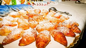 A variety of pastries, including croissants and other baked goods, arranged on a table.