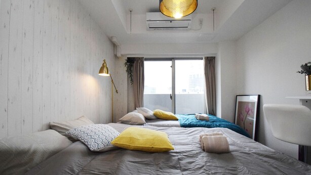 Una habitación de hotel moderna con una cama grande, un escritorio y una ventana con cortinas.