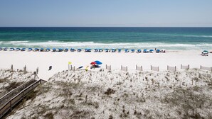 A beach with white sand, a wooden boardwalk, and a wooden fence. - SD 508: Beachfront Boho - Indulge in Sunset Serenity with Gulf Views! (Fort Walton Beach)