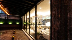 Ein modernes Interieur mit Glaswand, Ziegelboden und Decke mit freiliegenden Balken.