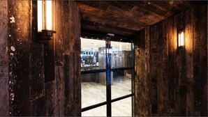 Ein Holzkamin mit einer Glastür, die in einen Barbereich führt.