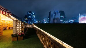 Ein Nachtblick auf eine Skyline mit beleuchteten Gebäuden und einer Brücke mit einem einzigartigen geometrischen Design.