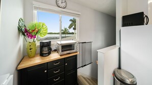 A compact kitchen with a toaster oven, a coffee maker, and a clock on the wall. - Escape to Kokomo Bay,  Escape to Paradise (Fort Myers)