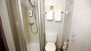 Ein Badezimmer mit Duschkabine, Toilette und Waschbecken.