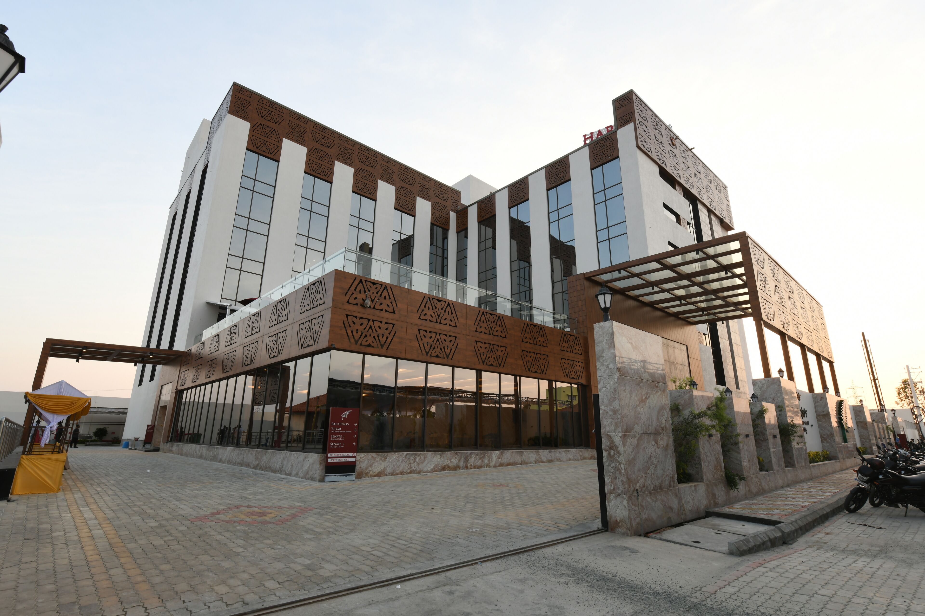 Un edificio moderno con facciata decorata, ampie finestre e area d'ingresso coperta.