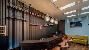 A bar area with a long counter, multiple stools, and a neon sign. - Ramada by Wyndham Frankfurt Central Station (Frankfurt)