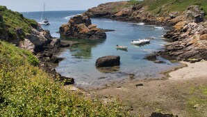 A coastal landscape with rocky terrain, clear water, and boats. - On a 3h property, in the heart of the forest, the gites du lety await you. (Perret)