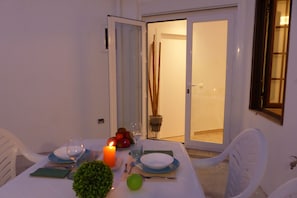 Enjoy a romantic dinner for two in this serene outdoor dining area, complete with a beautifully set table and a lovely view.