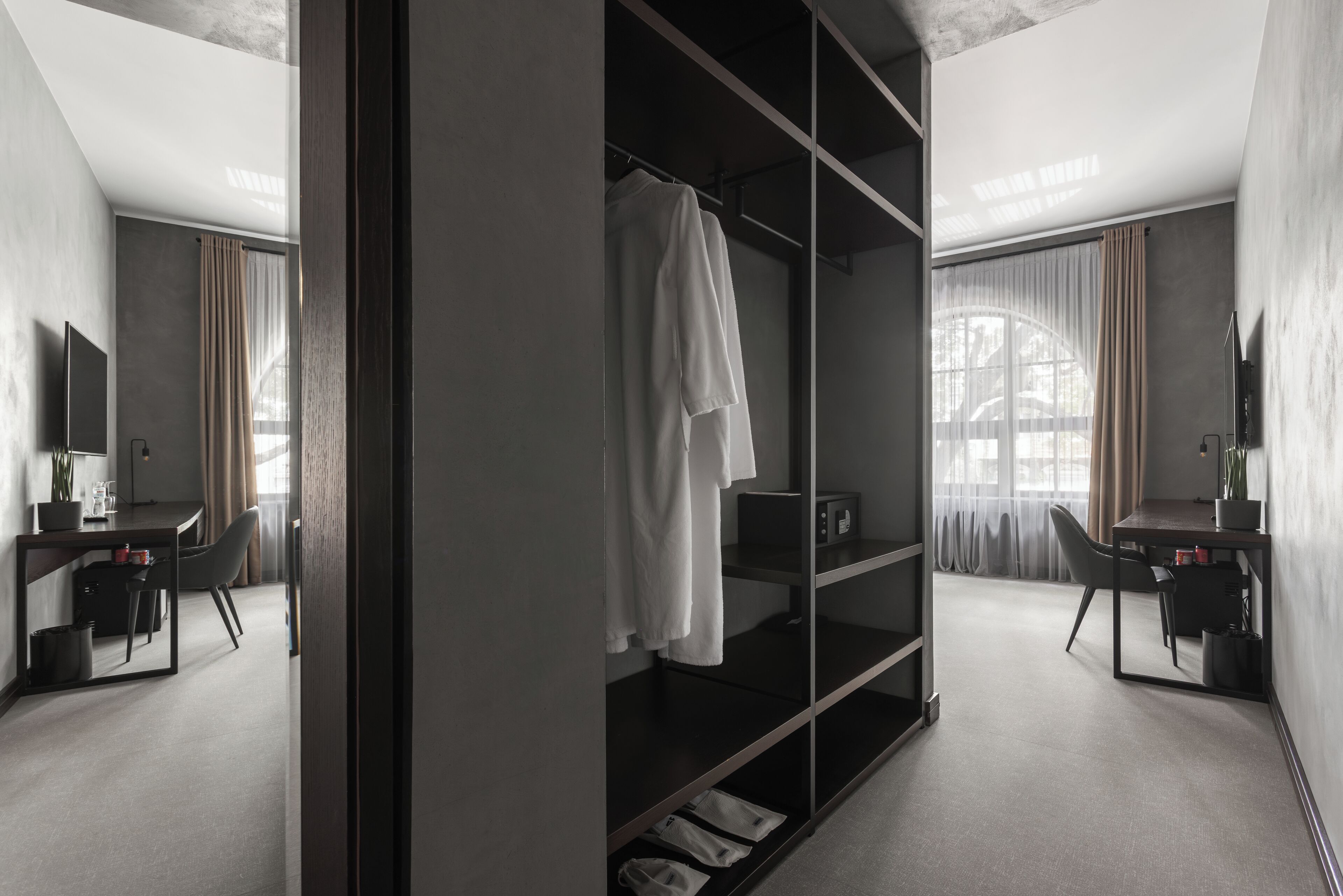 Habitación de hotel moderna con un armario grande, un escritorio y una silla.