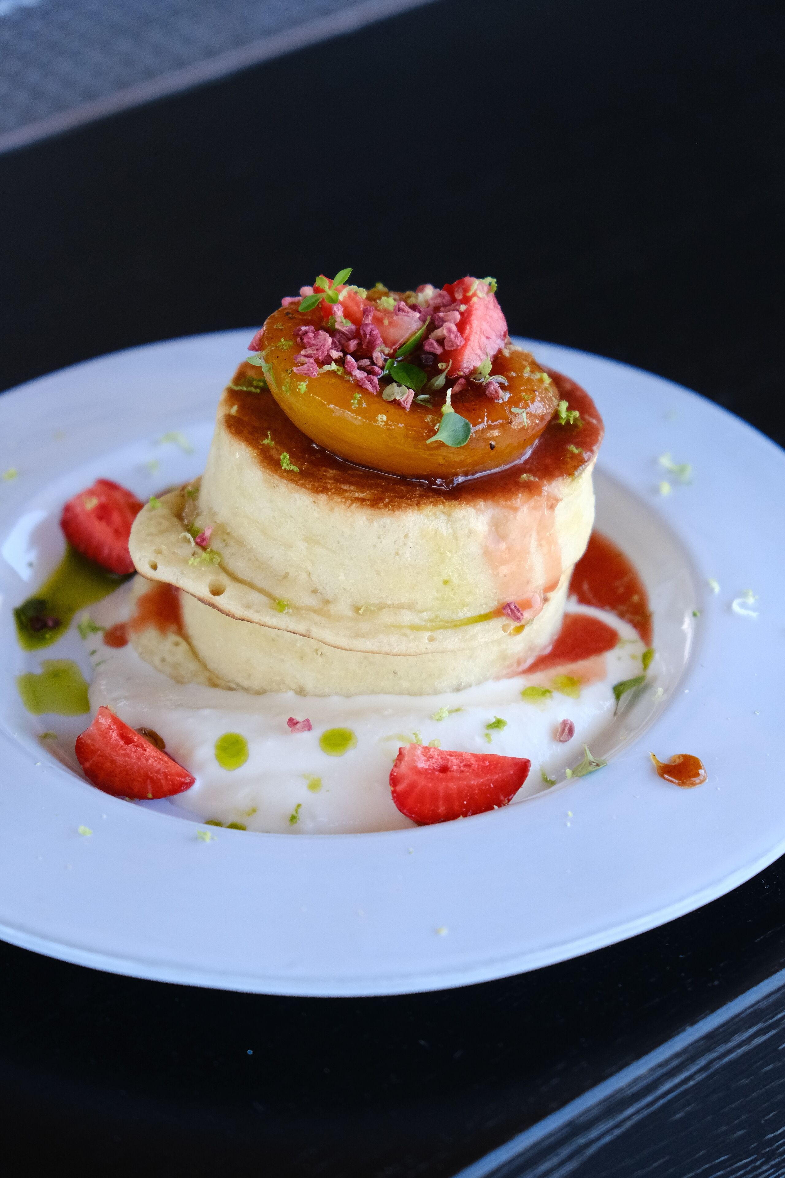 Ein Dessert auf einem weißen Teller vor dunklem Hintergrund.